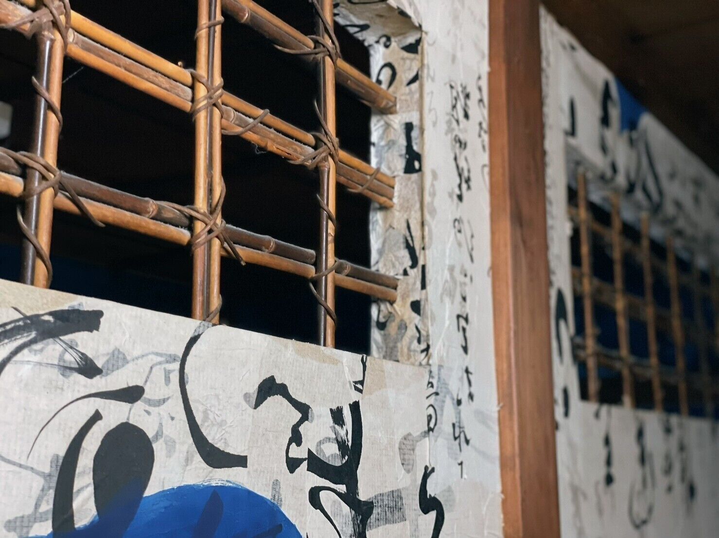 A building with bamboo scaffolding and a wall with Japanese characters.