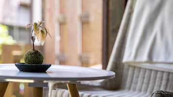 A round table with a potted plant on it, placed on a wicker chair.