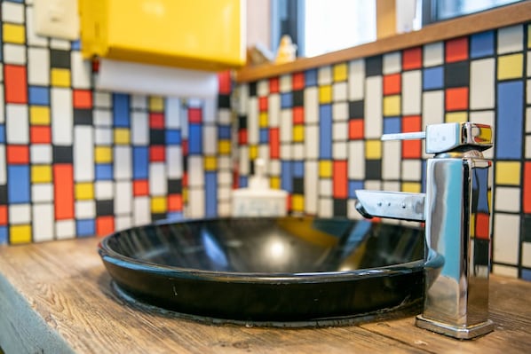 Una cocina con un salpicadero de azulejos coloridos y un grifo moderno.