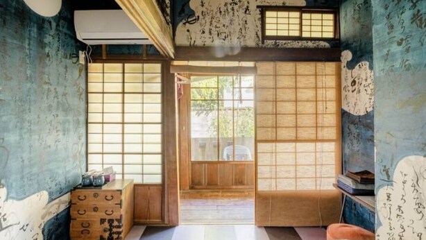 Um quarto japonês tradicional com tatames, portas deslizantes e um painel shoji.
