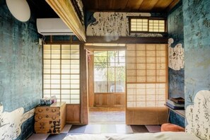 A traditional Japanese room with tatami flooring, sliding doors, and a shoji screen. - Villa Sacra (Kamakura)