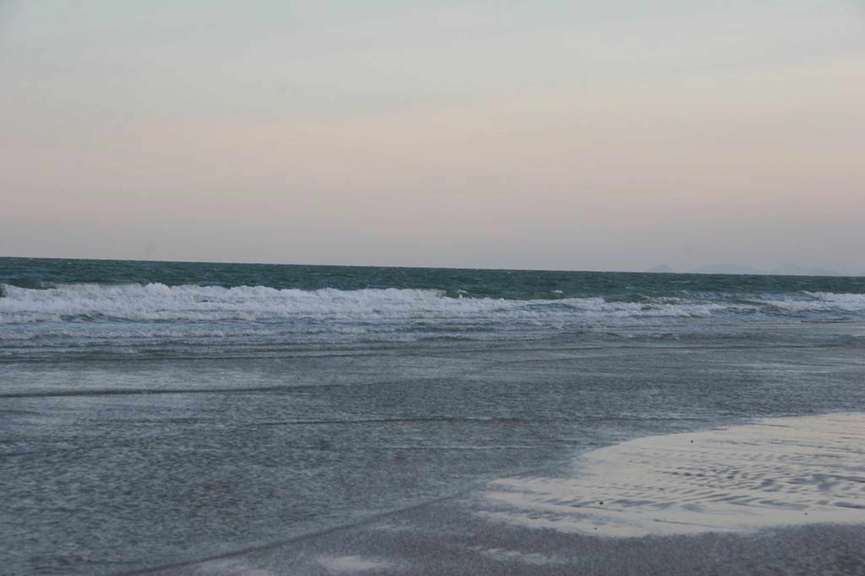 Una playa con olas que se acercan a la orilla.