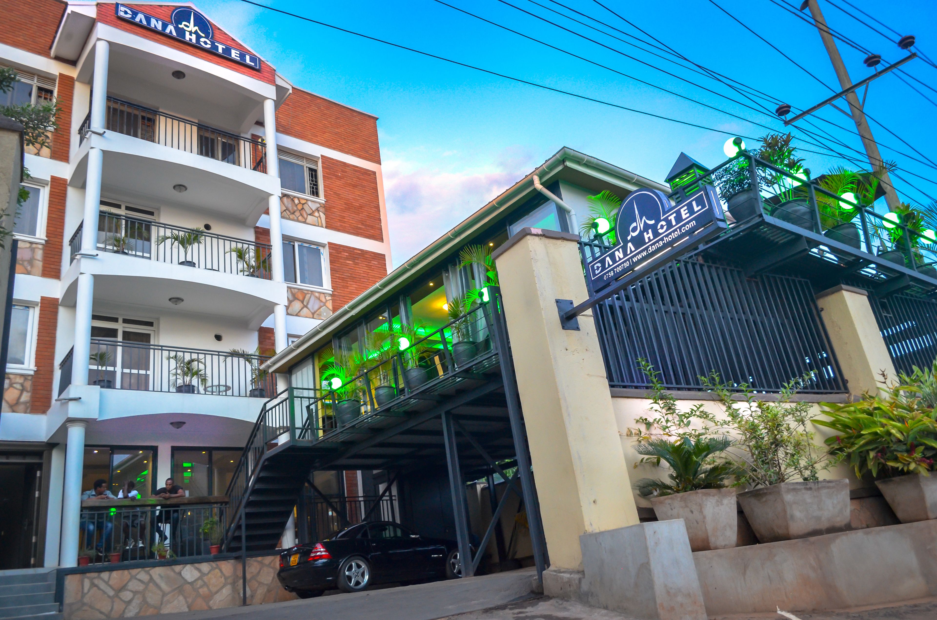 A hotel with a prominent sign, multiple balconies, and outdoor seating areas.