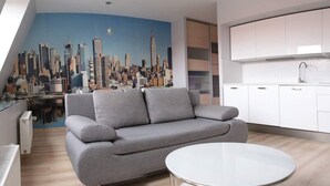 Una sala moderna con un sofá gris, una mesa de centro blanca y un mural con vista a la ciudad en la pared.