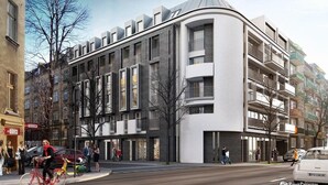 Un edificio moderno de varios pisos con balcones, ventanas amplias y un diseño de esquina curvada.