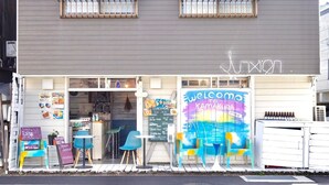 Un restaurante con fachada colorida, un menú en pizarra y mesas al aire libre.