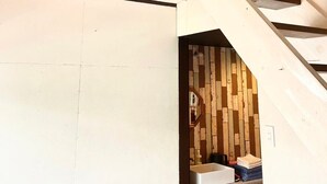 Una escalera con barandilla de madera y pared blanca.