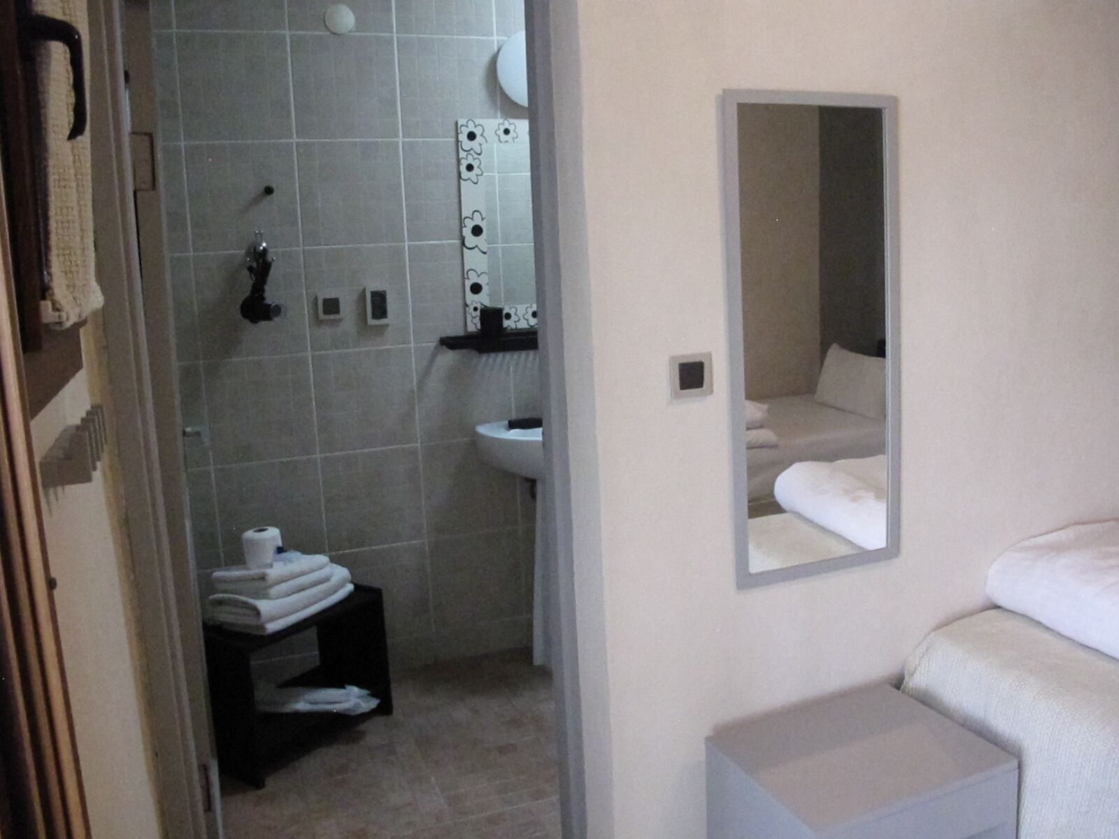 A bathroom with a shower, sink, and a mirror.