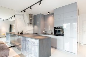 Apartament Deluxe | Cuina bàsica privada | Frigorífic, placa de cuina, rentaplats i cafetera i tetera 