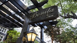 A wooden sign with the name "Bonita Inn" under a pergola with a lantern.