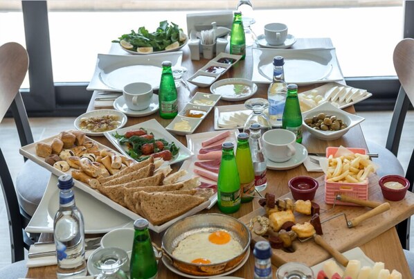 Un bufé de desayuno con diversos alimentos y bebidas.