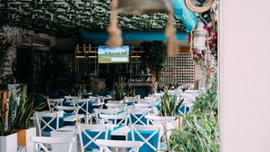 An outdoor seating area with white chairs and tables, surrounded by greenery and potted plants. - Sor Hotel Eskisehir (Eskisehir)