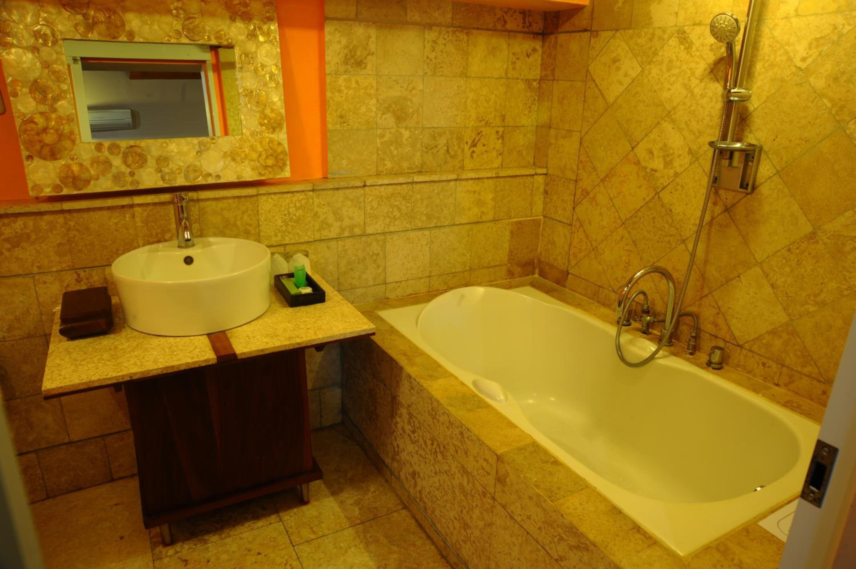 A bathroom with a sink, mirror, and bathtub.