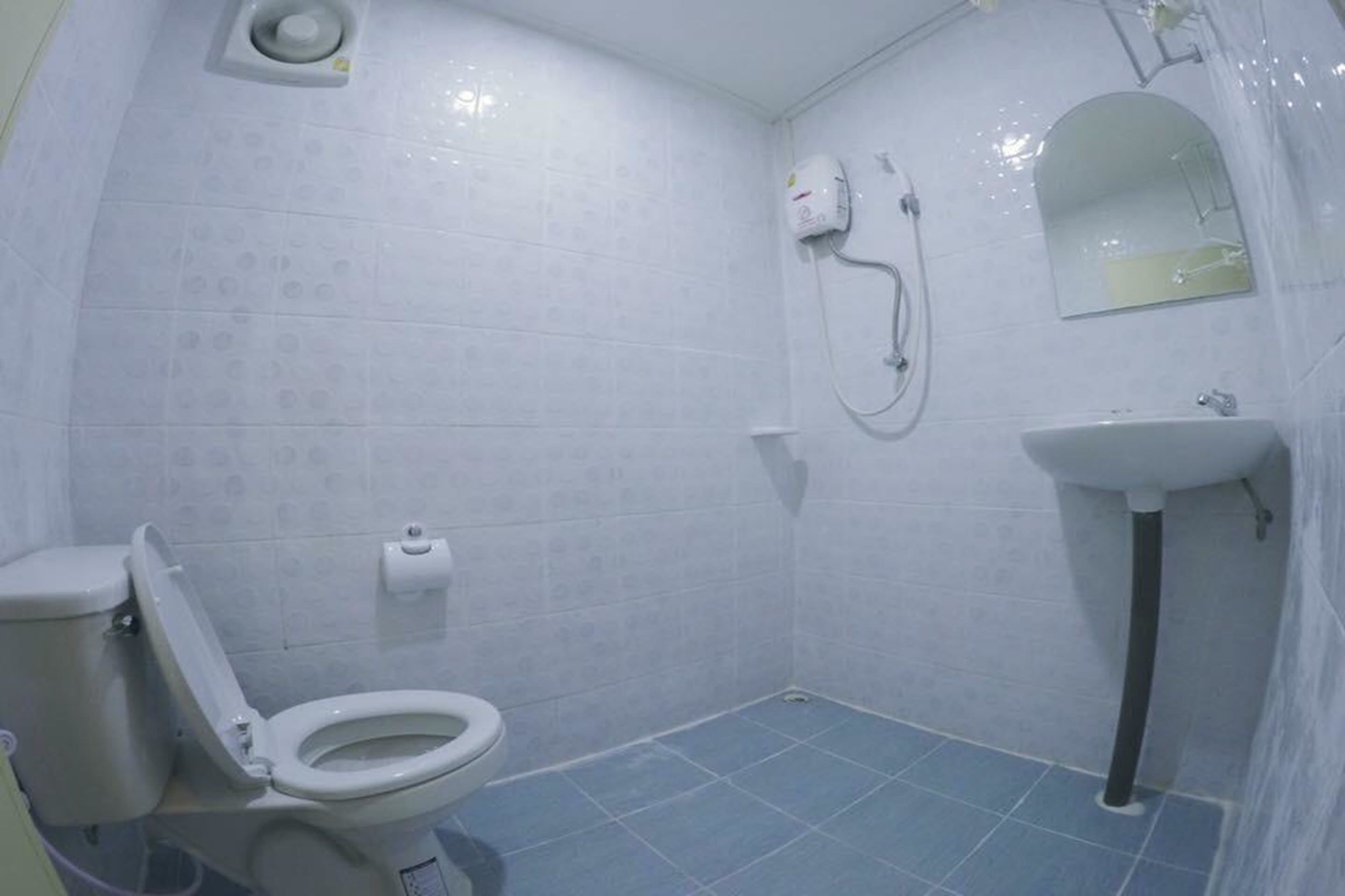 A small bathroom with a toilet, a sink, and a shower.
