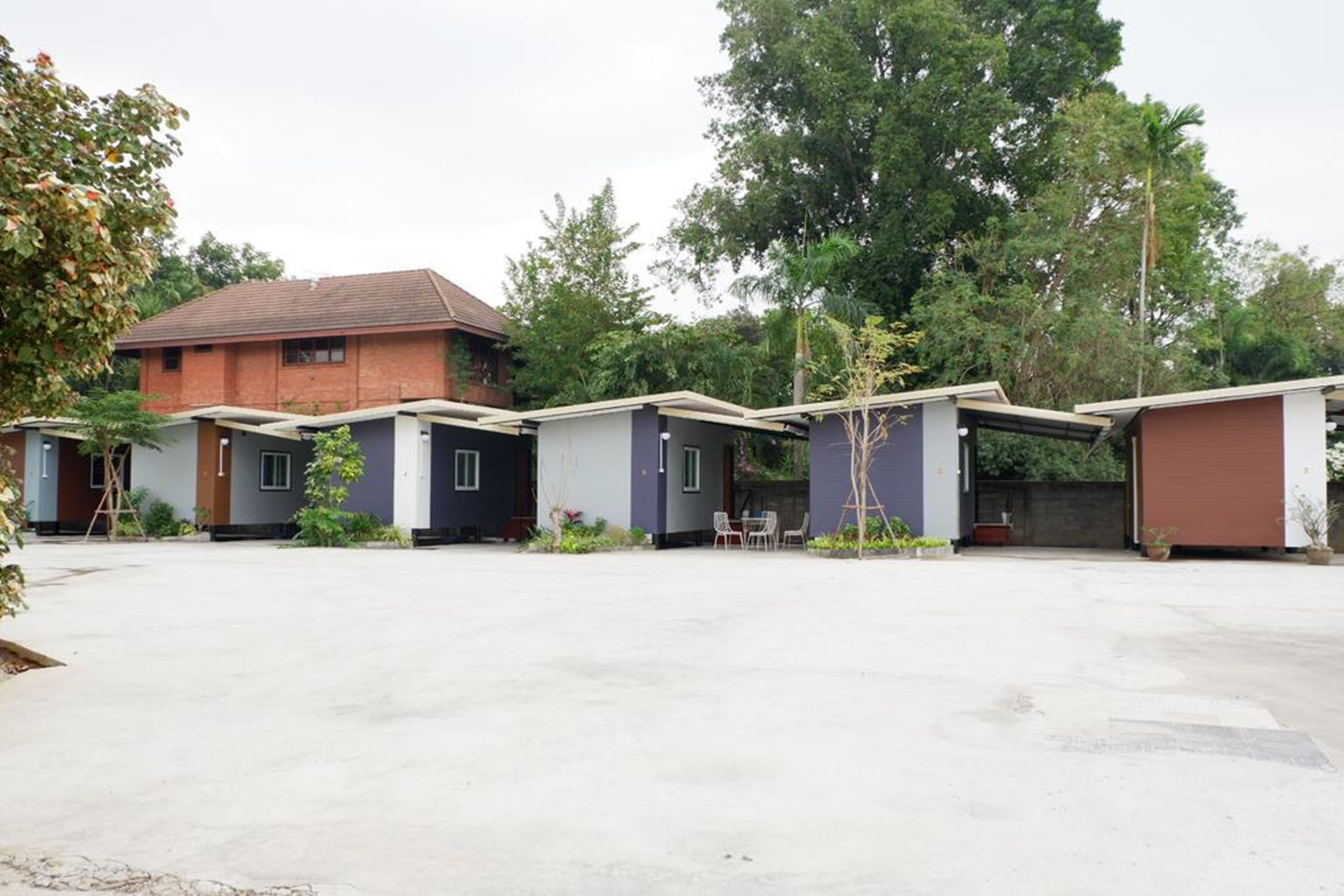 A row of single-story buildings with a flat roof, likely part of a residential or small hotel complex.