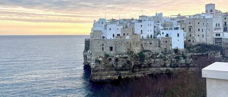 Un pueblo costero con edificios construidos sobre un acantilado con vistas al mar.