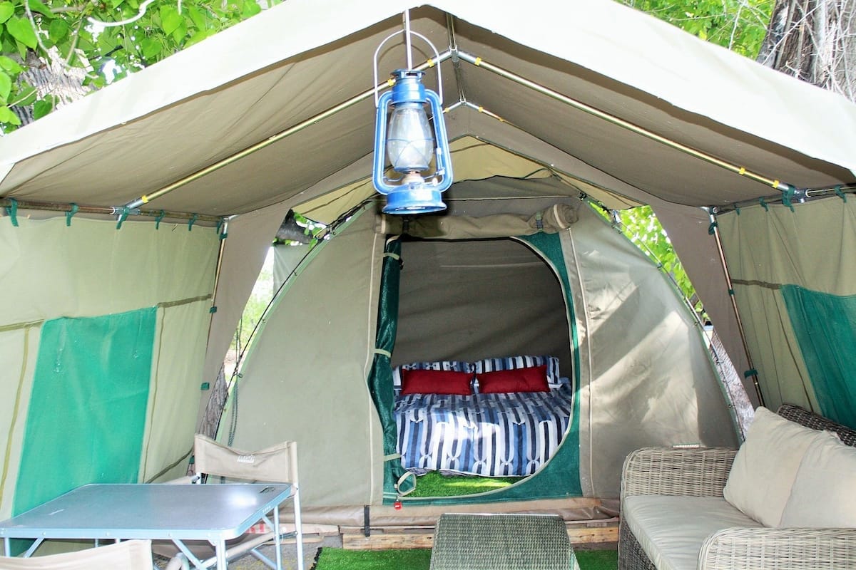Una carpa con una cama, una mesa y una silla en su interior.