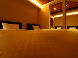 Une chambre d’hôtel avec un grand lit, un plafond en bois et un miroir au mur.