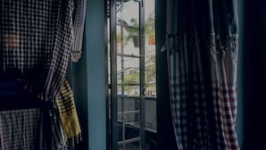 A room with a checkered curtain, a bench, and a view of the outside. - LeuLeu Hostel 2 (Xuan Huong - Da Lat)