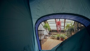 A tent with a view of a wooden deck, potted plants, and a hanging red rope. - LeuLeu Hostel 2 (Xuan Huong - Da Lat)