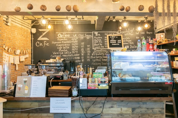 A cafe with a chalkboard menu listing coffee and tea options.