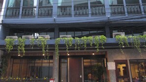 Un immeuble à plusieurs étages doté de grandes fenêtres en arc de cercle et de balcons.