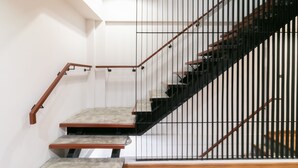 Un escalier moderne avec une barrière en verre, des rampes en bois et un sol en béton.