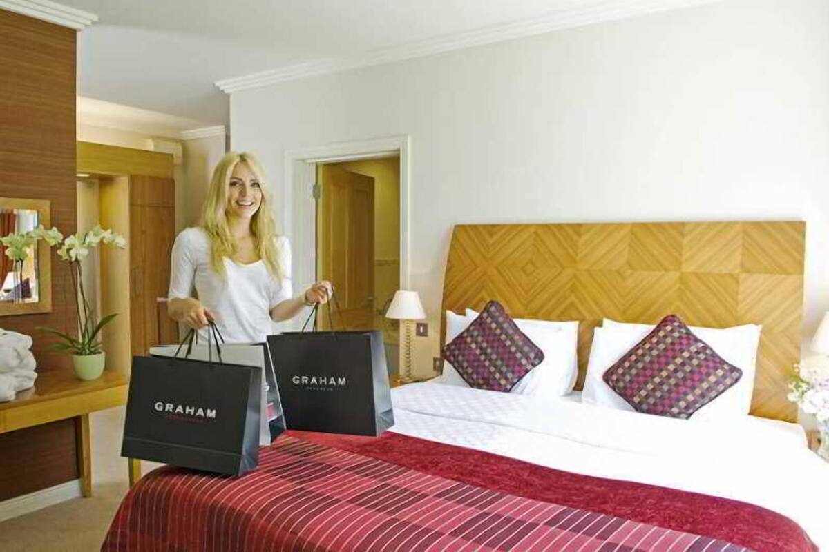 Une chambre d’hôtel avec un lit, une table de chevet, une lampe et une fenêtre.