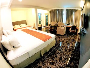 Een hotelkamer met een groot bed, een bureau, een stoel en een bank.