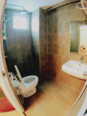 Een badkamer met toilet, wastafel en douche.