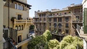 Un edifici de diversos pisos amb balcons, grans finestres i vista al carrer.