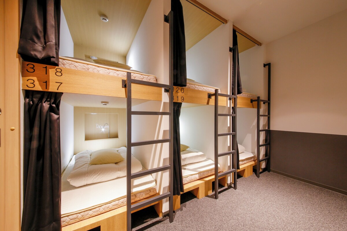 A bunk bed room with wooden frames and numbered beds.