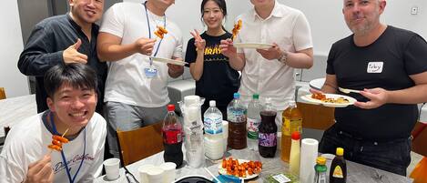 A group of people at a dining table with various food items and condiments.