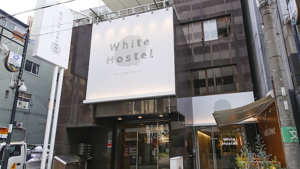 Un edificio con un cartel grande que dice "White Hostel" y un cartel más pequeño debajo.