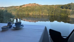 Una taula amb vista a un llac i turons boscosos.