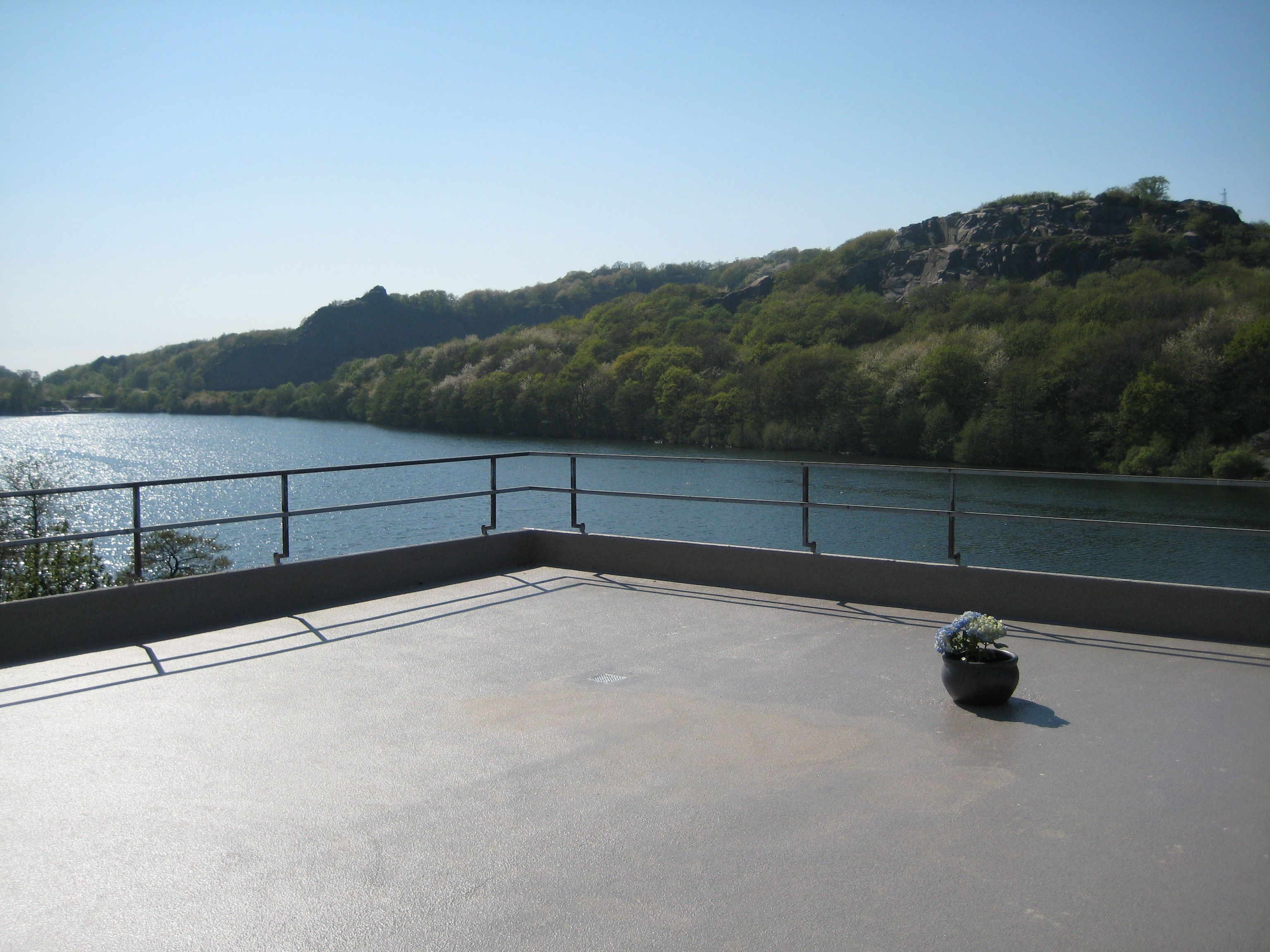 Un balcón con vistas a un río y una colina.