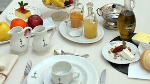 A table set for a meal with various dishes, drinks, and condiments. - Hotel La Posada del Infante (La Puebla de los Infantes)