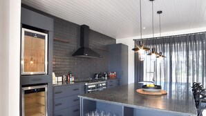 Una cocina moderna con electrodomésticos integrados, una isla central con cristalería y un diseño elegante.