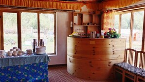 Ein rustikales Holzinterieur mit einem großen Fass, einem Tisch mit Geschirr und einer Bank.