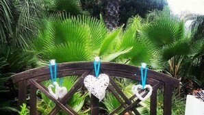 A wooden bridge with heart-shaped decorations and a small pond. - All'ombra del palmeto (Taranto)