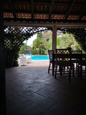 An outdoor patio area with a pool, chairs, and a covered seating area. - All'ombra del palmeto (Taranto)