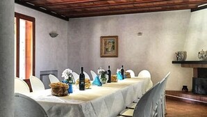 A dining area with a long table set for a meal, surrounded by chairs. - All'ombra del palmeto (Taranto)