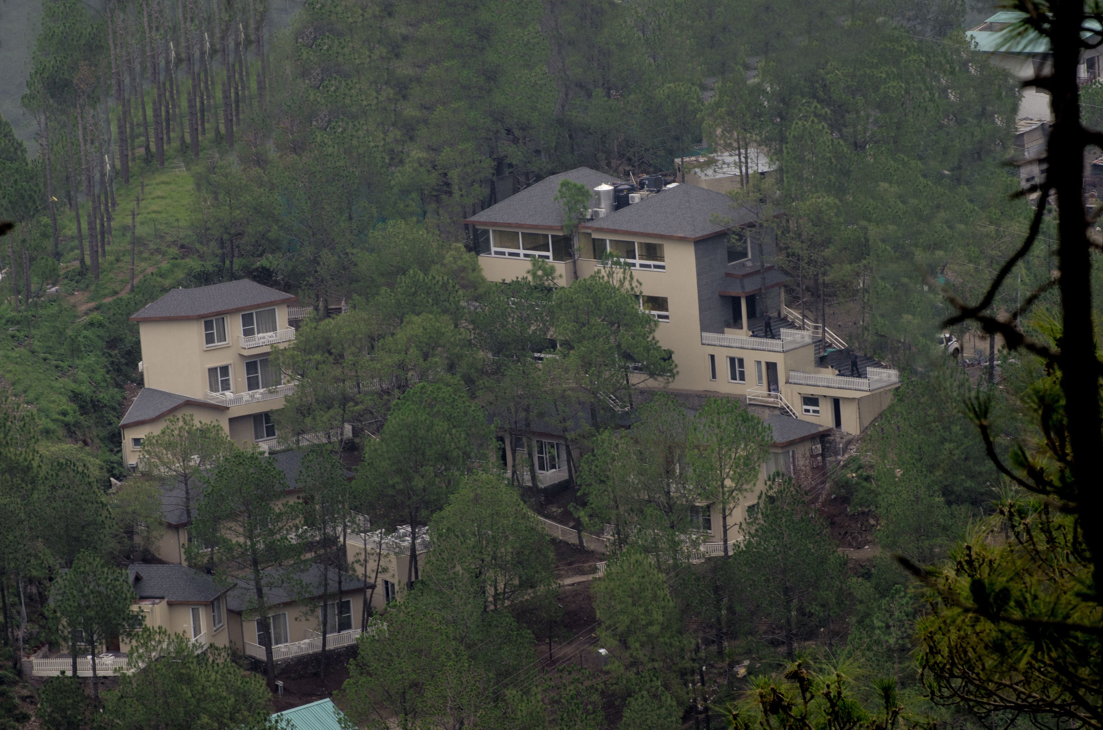 Un edificio residencial de varios pisos rodeado de un bosque frondoso.