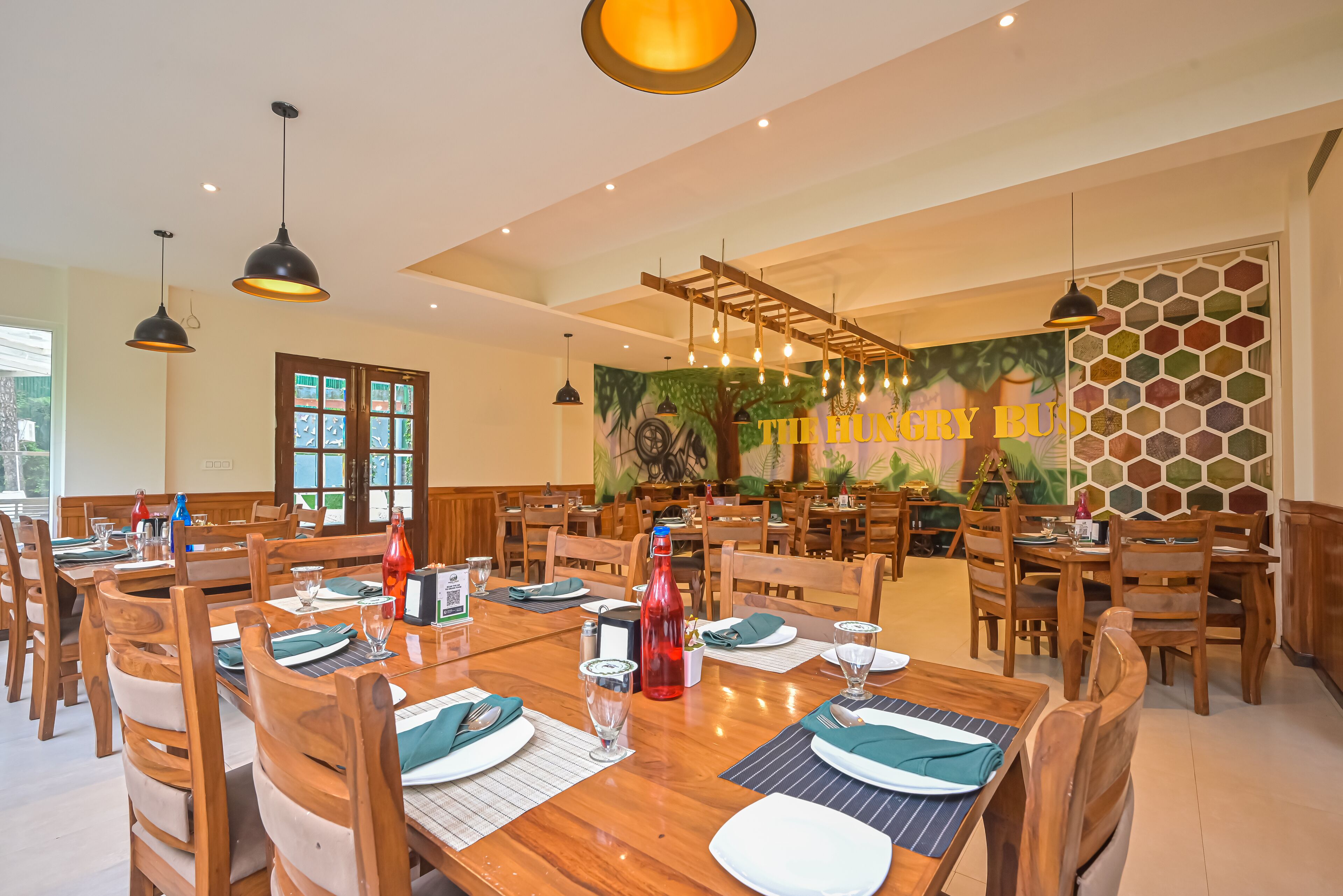 A restaurant with wooden tables and chairs, a mural, and a sign reading "THE HUNGRY BUNNY."