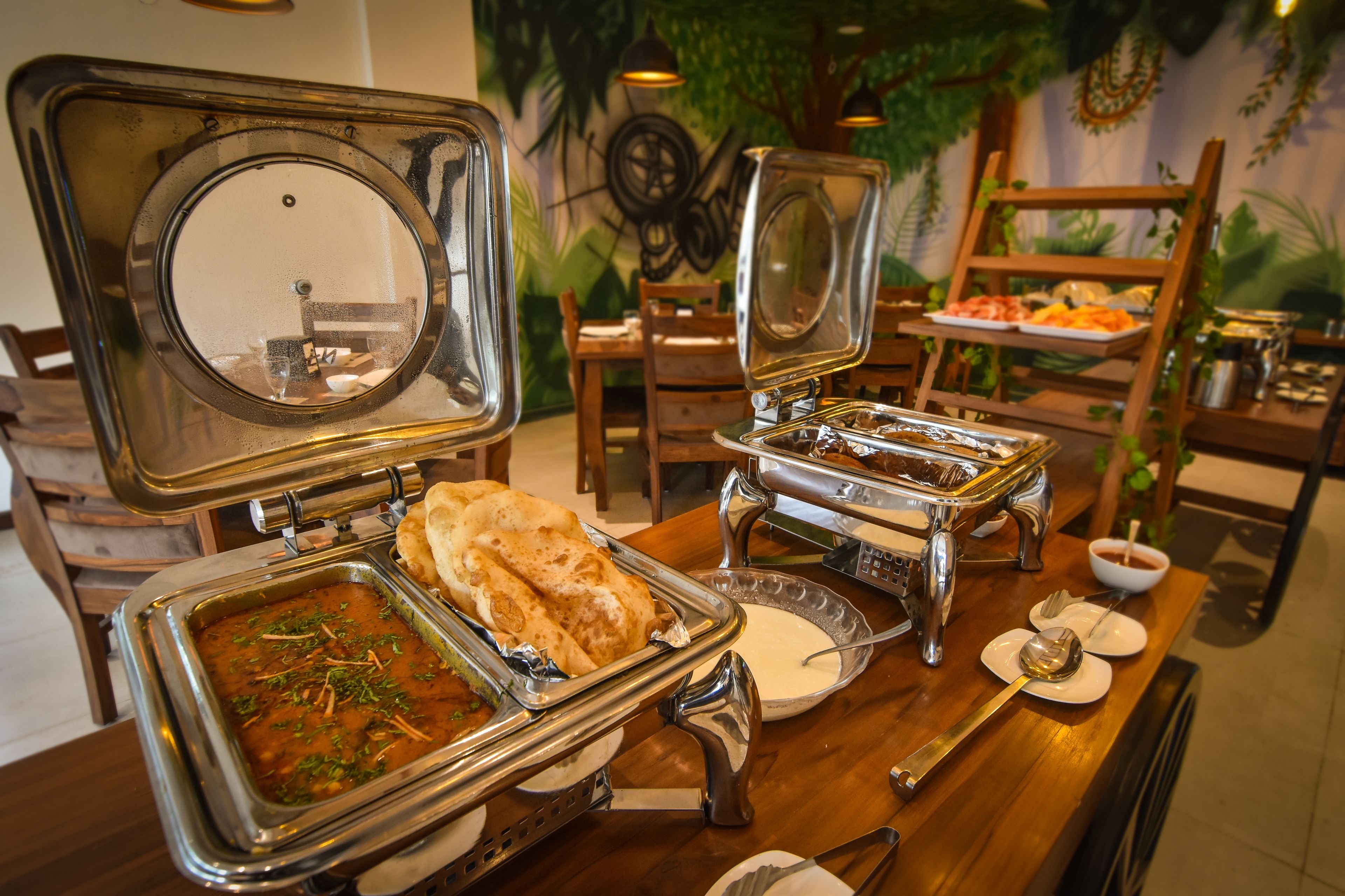 A buffet setup with various dishes and utensils.