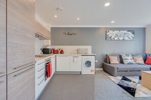 Een koelkast met diepvriezer, een microgolfoven, een oven, een kookplaat