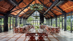 A large, open dining area with high ceilings and large windows, featuring wooden tables and chairs, and a hanging floral arrangement. - Palac Mala Wies (Belsk Duzy)