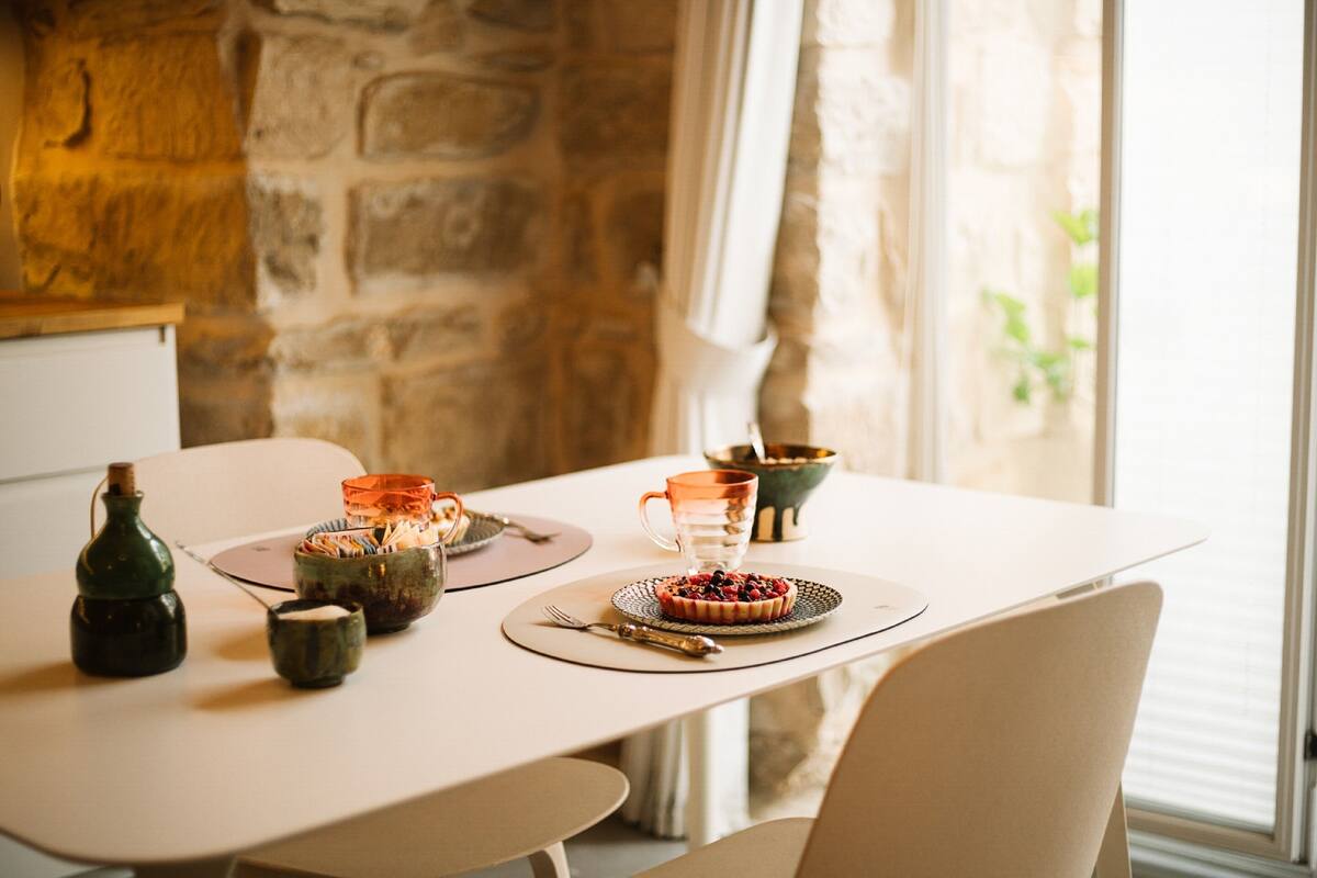 A dining table set with plates, cups, and a small decorative item.