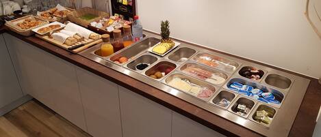 A buffet setup with various food items and condiments.