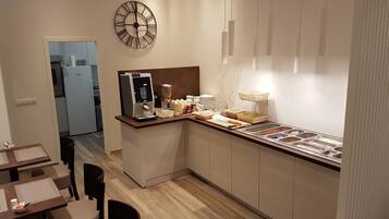 A modern kitchen with a breakfast bar, a clock, and a buffet area.